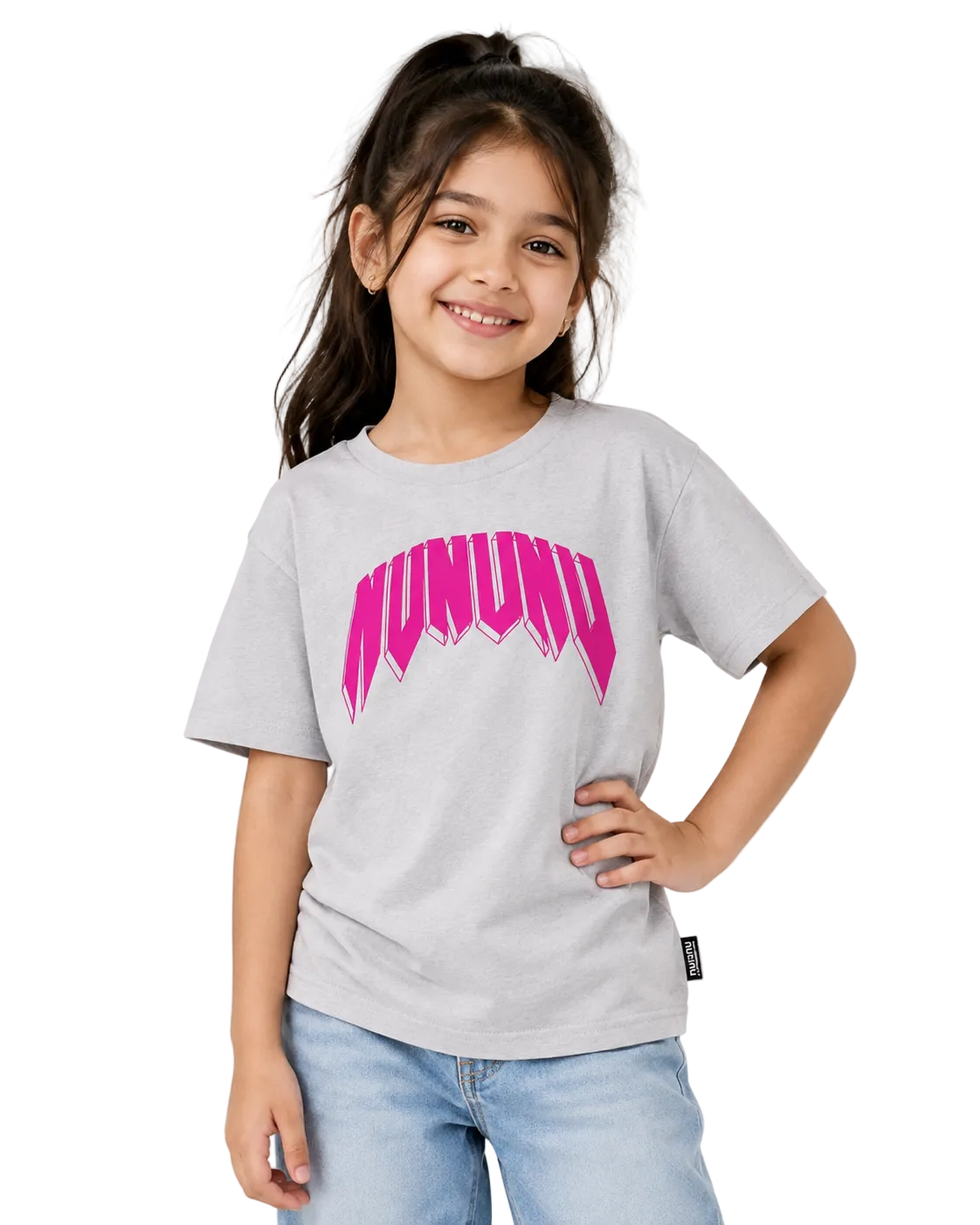 A young girl with dark hair in a ponytail smiling while wearing a light gray heather t-shirt with a vibrant pink 'MUNUDO' graphic on the chest, paired with light blue jeans, against a plain light gray background.