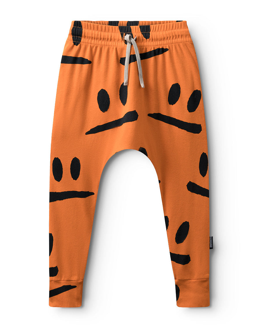 Orange pants with black smiley face patterns on a white background